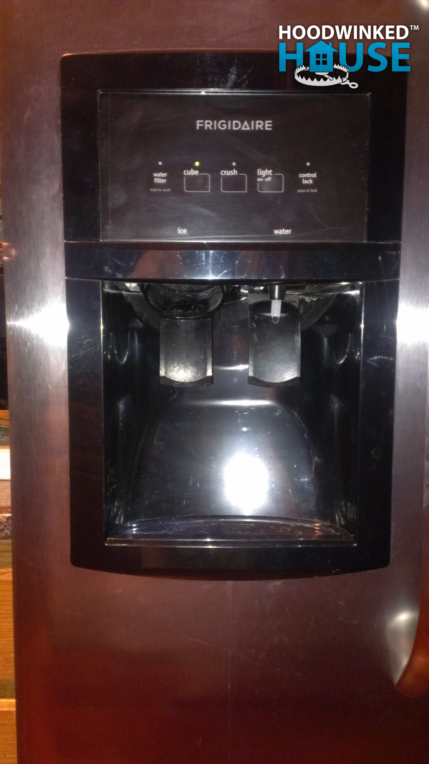 Water and ice dispenser on the front of a Frigidaire refrigerator.