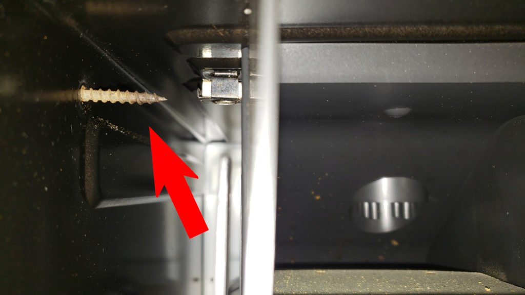 Drywall screw puncturing the side of a microwave housing.